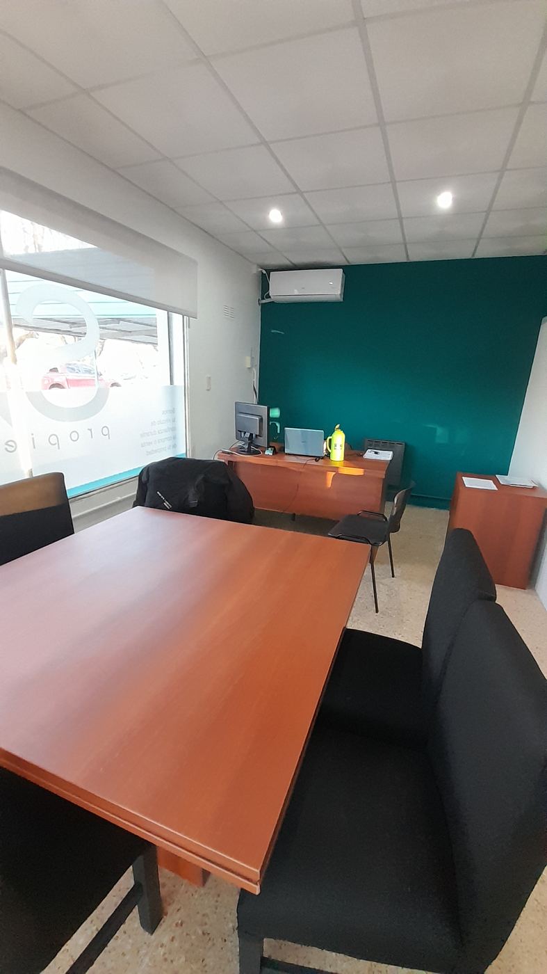 Sala con escritorio y pared color petróleo